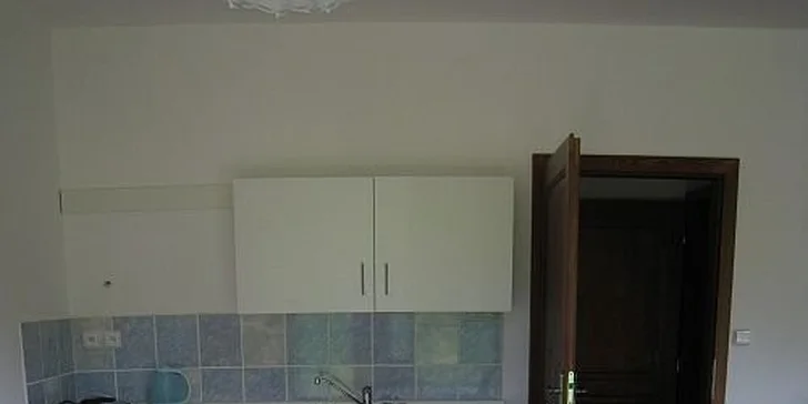 V apartmánech je obývací pokoj s kuchyňským koutem a jídelním stolem.