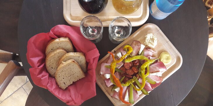 Příjemné posezení ve vinárně: Láhev vína a prkénko plné masa a sýrů