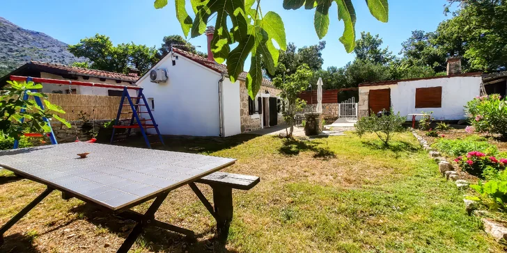 Záhradný dvor plný kvetov a fíg, kde nájdete gril, hojdačku, lehátka aj vonkajšiu sprchu.