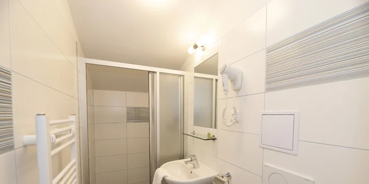 Součástí pokoje je také koupelna se sprchovým koutem. 