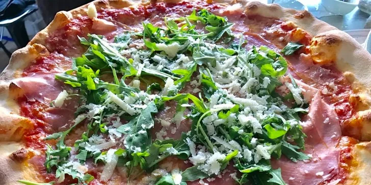 Pizzy jsou plné čerstvých surovin. Toto je třeba pancetta e rucola.