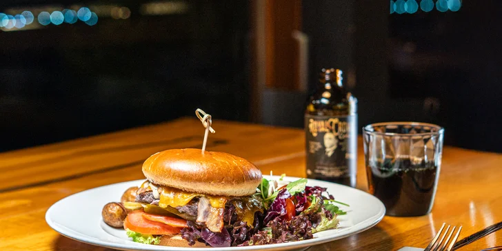 Burger je s hovězím masem a podává se s pečenými brambory grenaille a míchaným salátem.