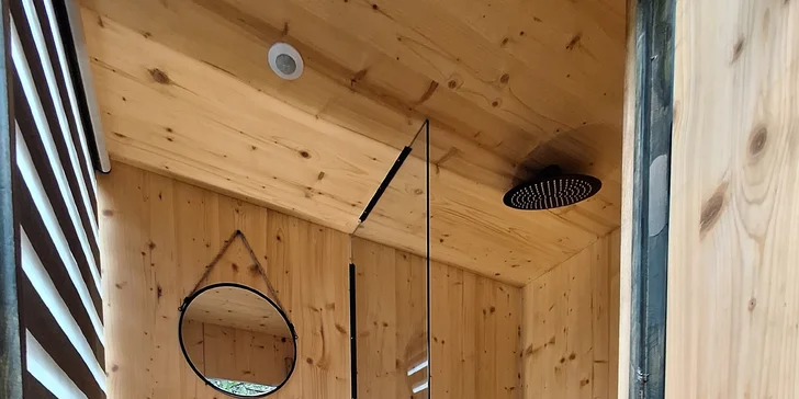 Vymazlený sprchový a záchodový domeček s teplou vodou poblíž posedu vám dodá pocit komfortu.