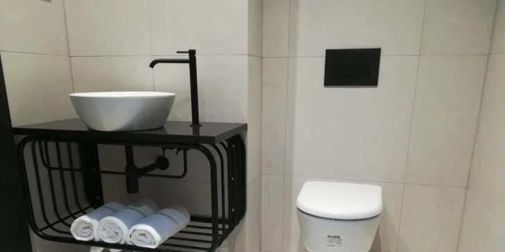 V koupelně je vana nebo sprcha. 