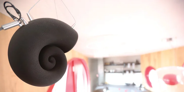 Obývací prostor vybavený 3D tištěnou repro soustavou i designovým osvětlením Brokis nebo policemi z 6000 let starého dubu poskytuje prostor pro relax i odpočinek.