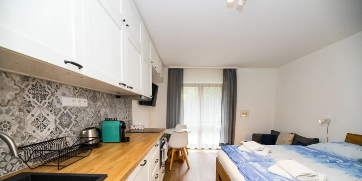 V kuchyni je trouba s mikrovlnkou, myčka, kapslový kávovar, lednice s mrazákem a dvouplotýnkový vařič.
