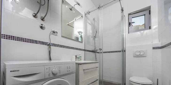 K apartmánom patrí kúpeľňa so sprchou a WC aj práčkou.