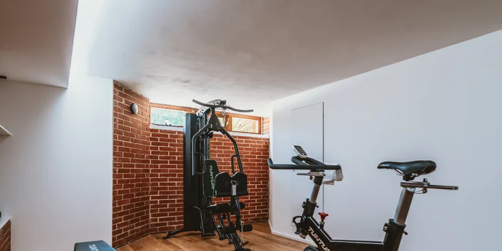 Klimatizované menší fitness s profesionálním vybavením – 2× běžecký pás, posilovací lavice, multifunkční věž a sada jednoručních činek. Sdílený vstup máte neomezený.