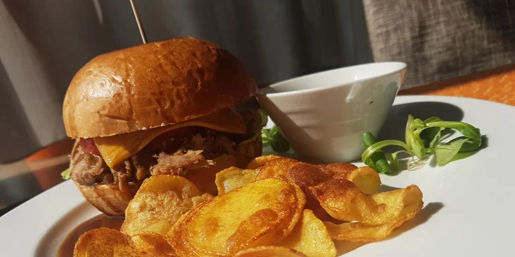 "Au Jus Burger" – trhané vepřové maso v natural bulce s čedarem, salátem, okurkou a švestkovou BBQ omáčkou, bramborové chipsy, omáčka demi-glace