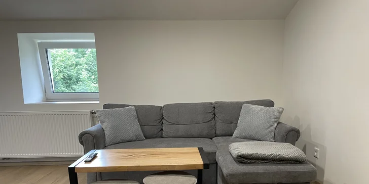 Srdcem apartmánu je moderní obývák s televizí, který navazuje na plně vybavenou kuchyň. 