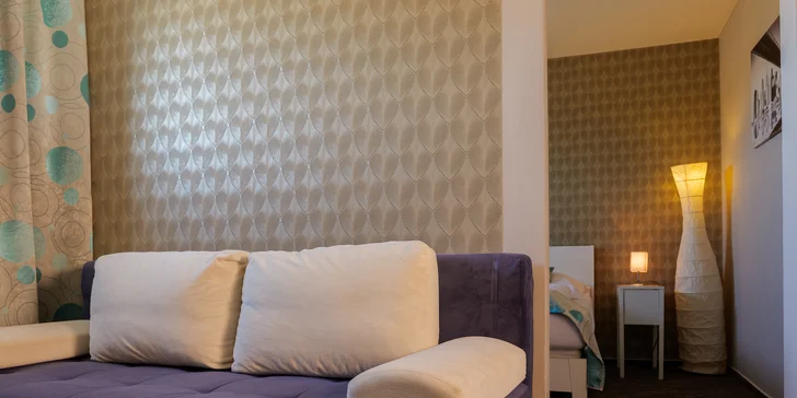 Apartmán DeLuxe má kromě ložnice také menší obývací pokoj s pohovkou.