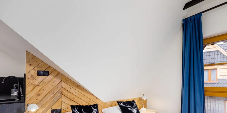Štýlová trojlôžková izba s tatranskými prvkami má aj kuchynský kút. 