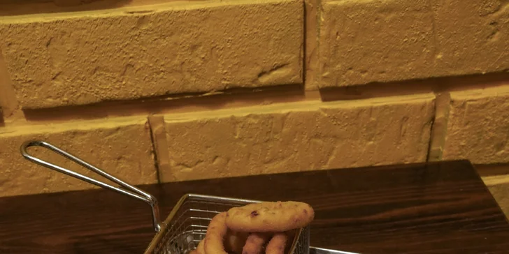 Na talíři vše doplní cibulové kroužky, Coleslaw a dip.