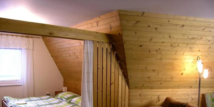 Ložnice je od obývacího pokoje oddělena závěsem.