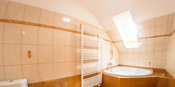 Apartmá má koupelnu s rohovou vanou.