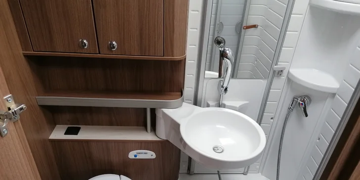 Toaleta má otočný záchod, umyvadlo, zrcadlo, skříňky na osobní hygienu a sprchu.