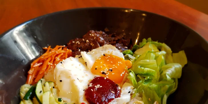 Ochutnáte tu polévku kimchi a tradiční bibimbap – restovanou hovězí roštěnou se sójovými klíčky, vaječnou omeletou, korejskou chilli pastou a spoustou dalších pochutin.