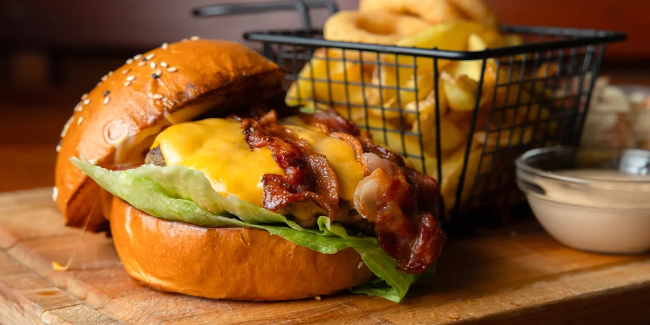 Poctivý hovädzí burger s hranolčekmi, šalátom a cibuľovými krúžkami